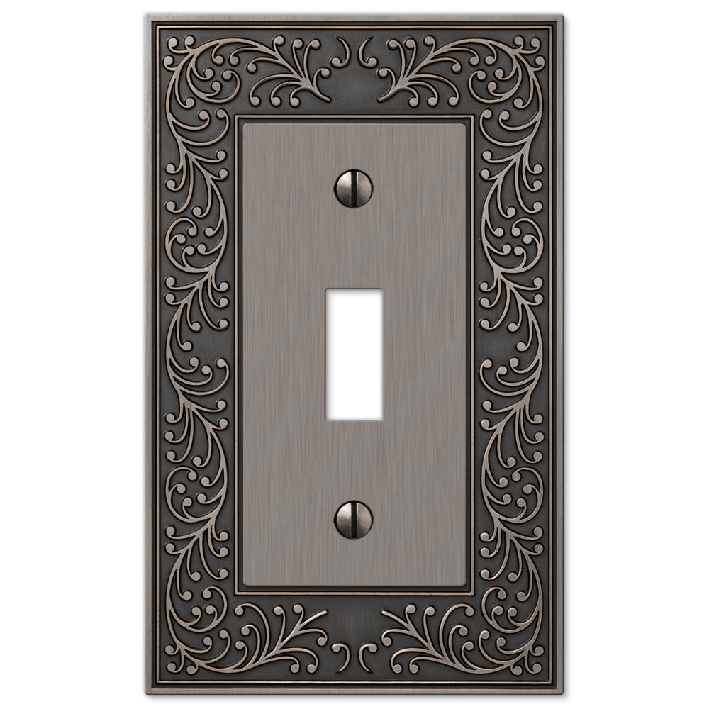 An antique nickel light switch cover from the English Garden collection, showcasing a soft, muted finish with subtle tarnishing that highlights its intricate, vintage-inspired design. The delicately aged patina adds timeless elegance, evoking the charm of a classic garden aesthetic.