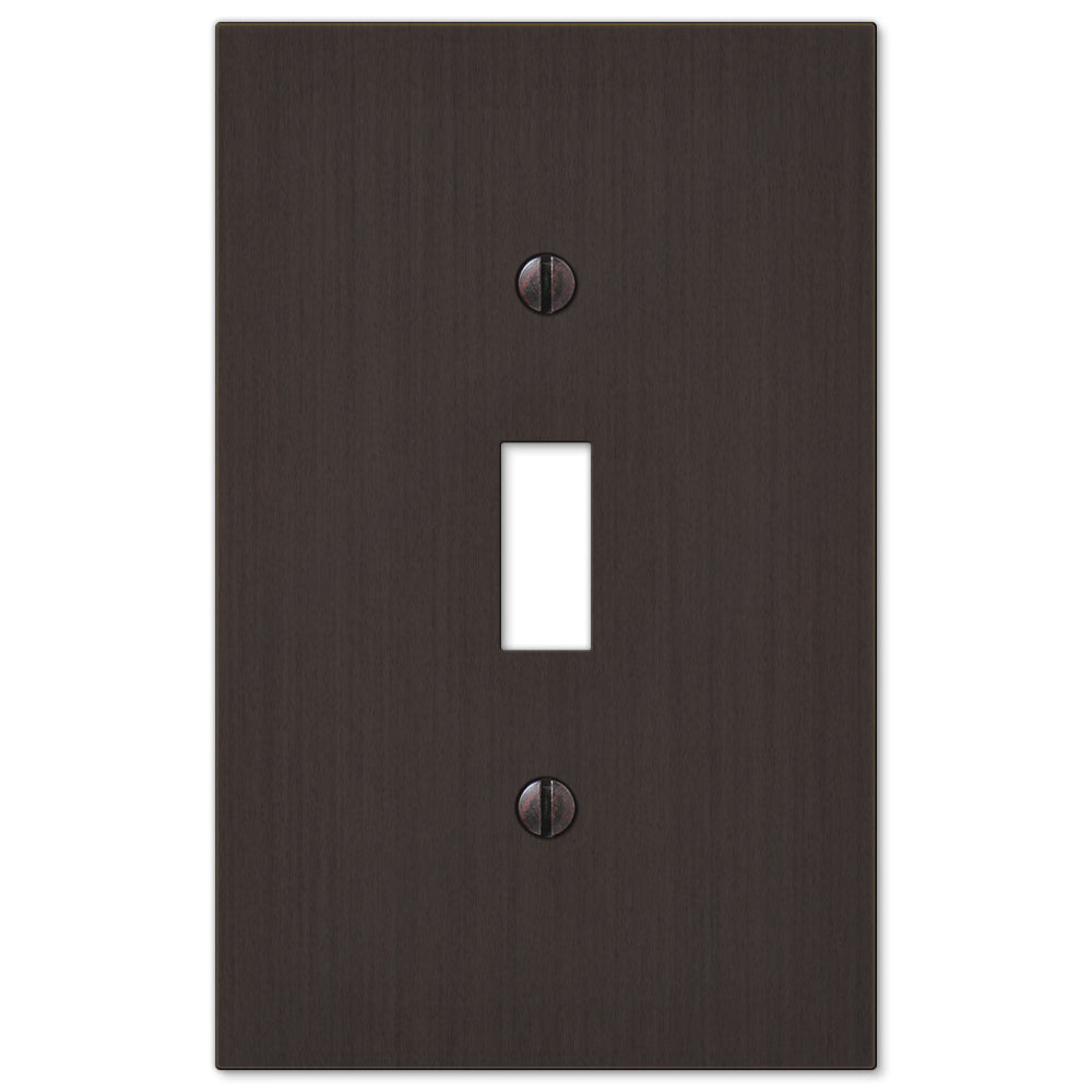 An aged bronze light switch cover from the Elan collection, featuring a rich, dark finish with subtle highlights that reveal its finely crafted details. The cover’s slightly weathered patina adds depth and character, creating a timeless, refined aesthetic.